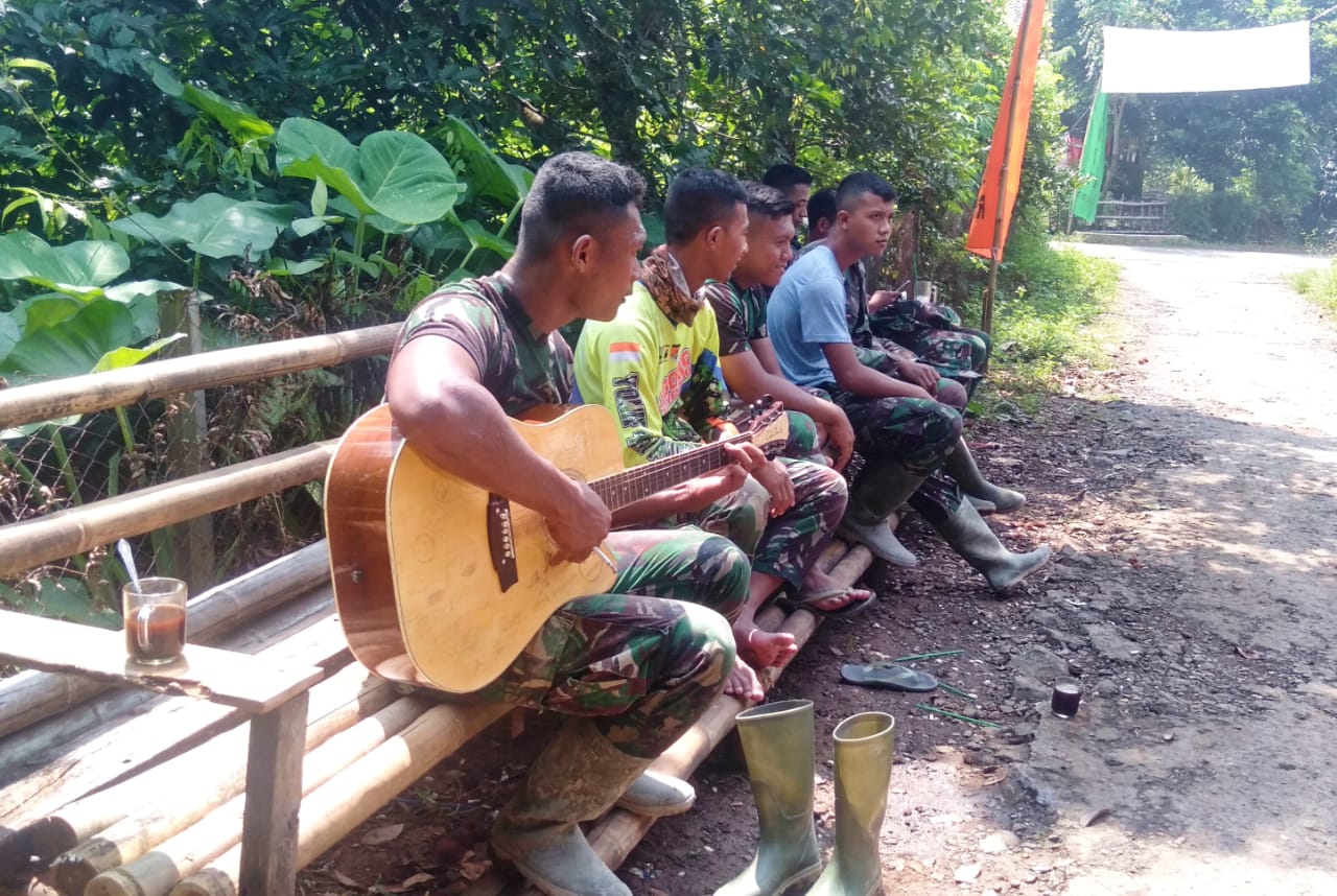 Prajurit Satgas TMMD Isi Waktu Luang Dengan Bermain Gitar
