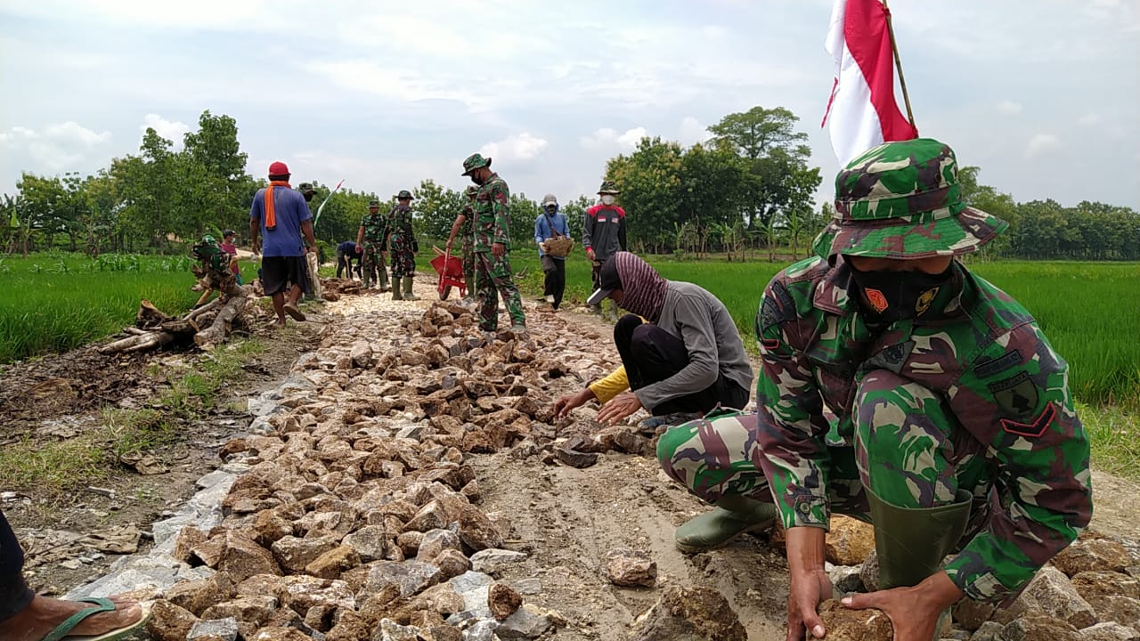 Bersama Dinas PU Cipta Karya, Satgas TMMD Kodim Bojonegoro Dan Warga Pasang Batu Dasar Pembangunan Jalan